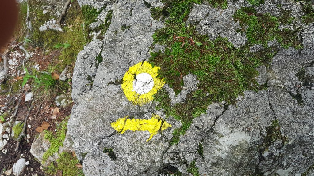 Gelbe Wegmarkierung an einem Felsen