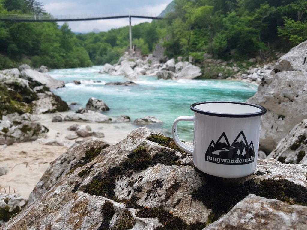 jungwandern-Tasse auf einem Felsen an einem Fluss