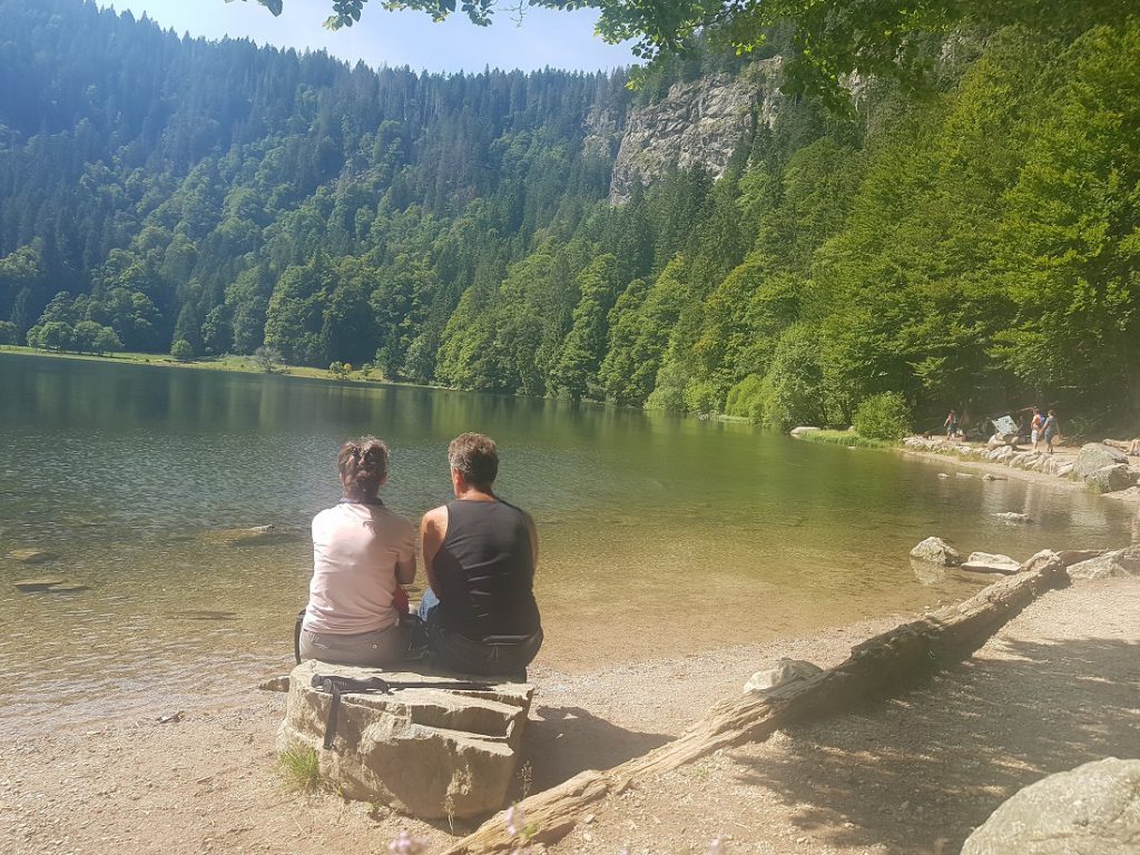 Mann und Frau sitzen an einem See