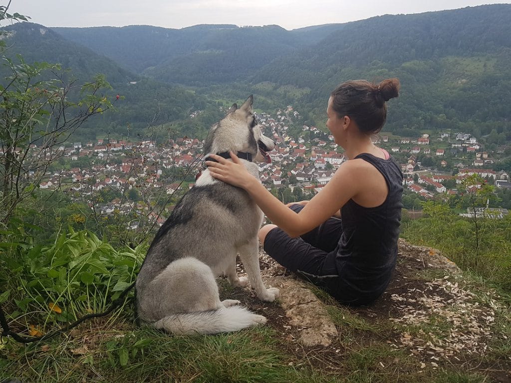 Frau mit Hund an Aussichtspunkt