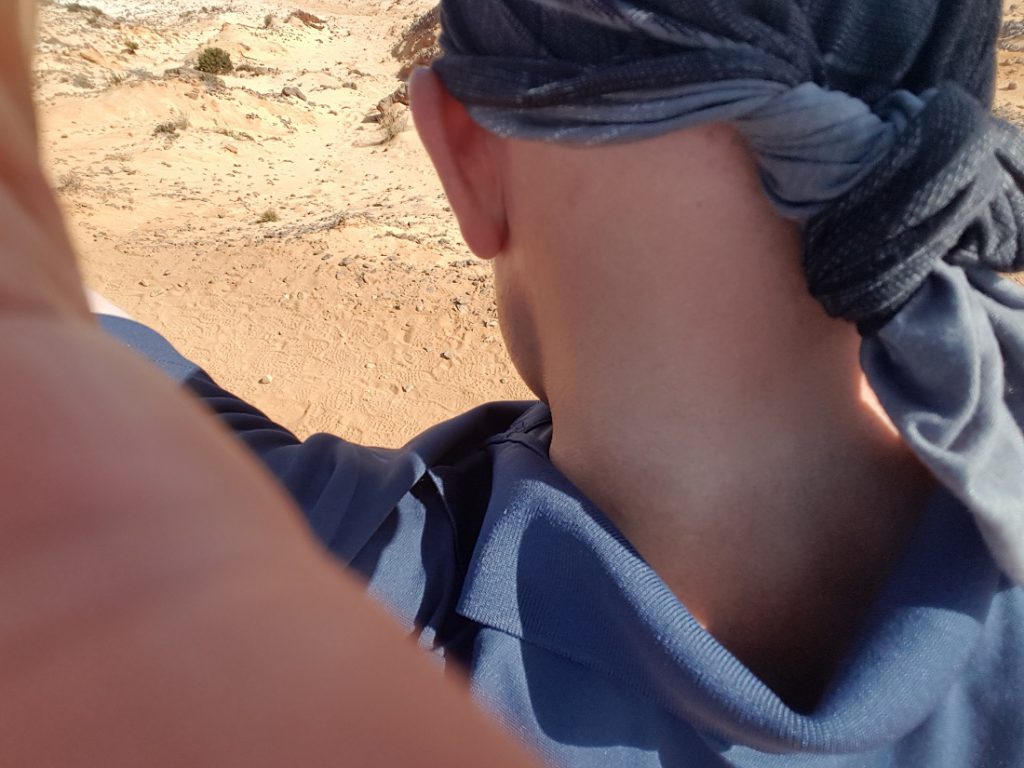 Mann bindet sich ein Bandana an den Kopf