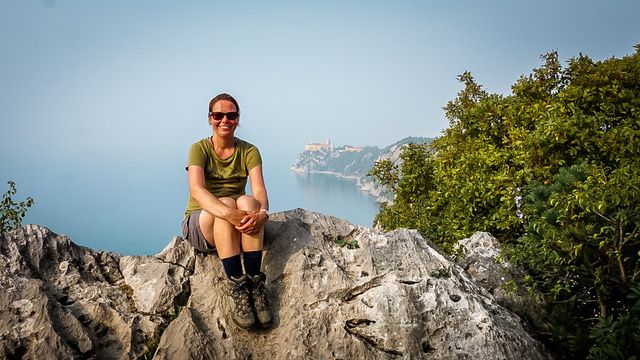 Outdoor Bloggerin Sabrina sitzt auf Felsen am Meer