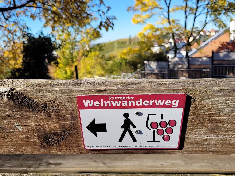 Wegmarkierung Stuttgarter Weinwanderweg mit Wanderer und Weintrauben