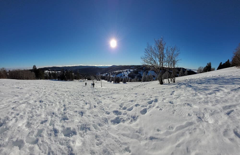 Schneelandschaft bei blauem Himmel mit strahlender Sonne