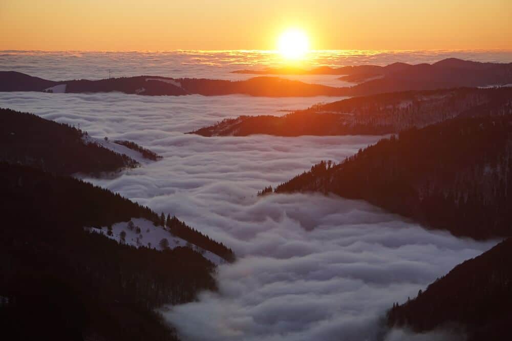 Atmosphärischer Sonnenuntergang mit Nebeldecke über dem Feldberg