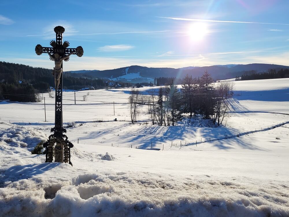 Kreuz auf winterlichem Wanderweg in Breitnau