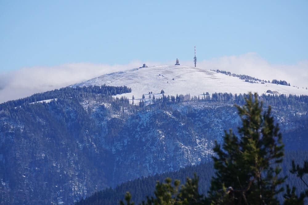 Blick vom Schauinsland auf den verschneiten Feldberggipfel