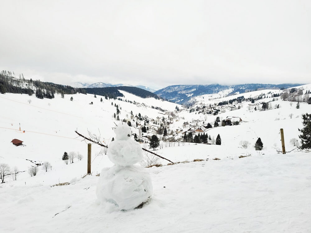 Schneemann in verschneiter Winterlandschaft