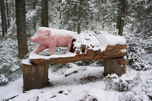 Verschneites Schwein aus Holzstamm