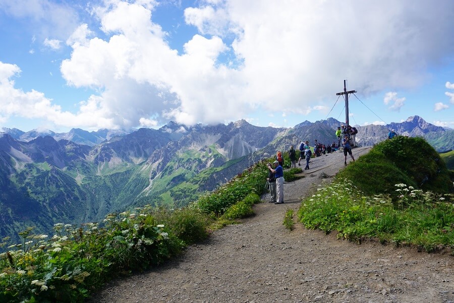 Panoramaaussicht auf Berge und Gipfelkreuz