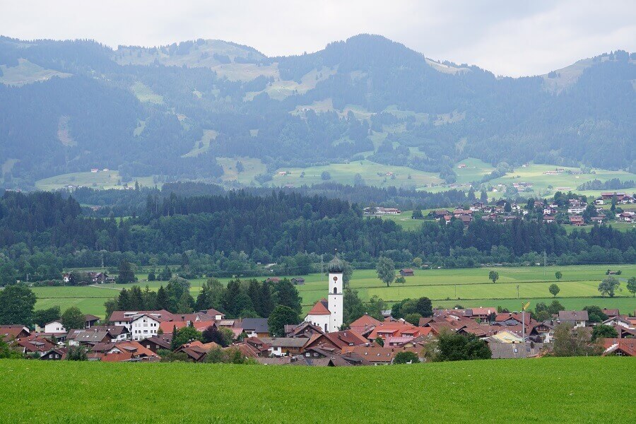 Blick auf ein Dorf mit Kirche und eine Bergkette