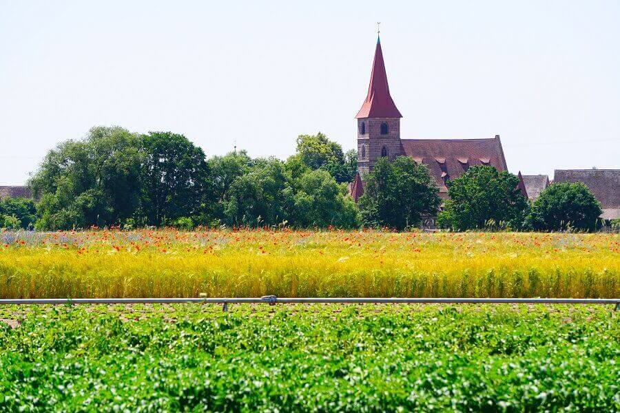 Kirche vor Gemüsefeld
