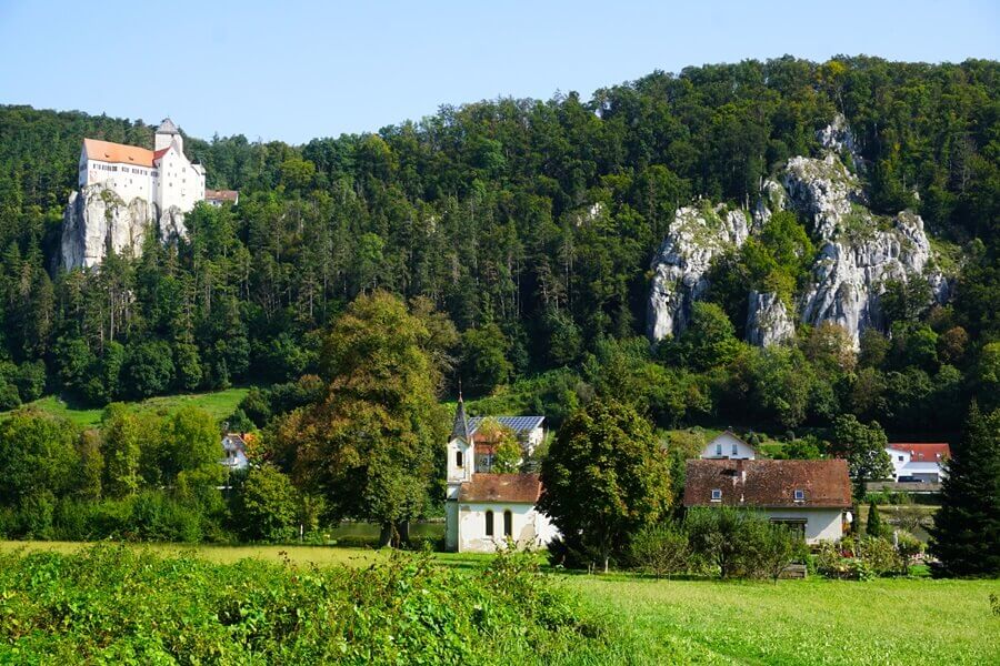 Links die Burg Prunn, rechts ein Kletterfelsen. Burg und eine kleine Kapelle