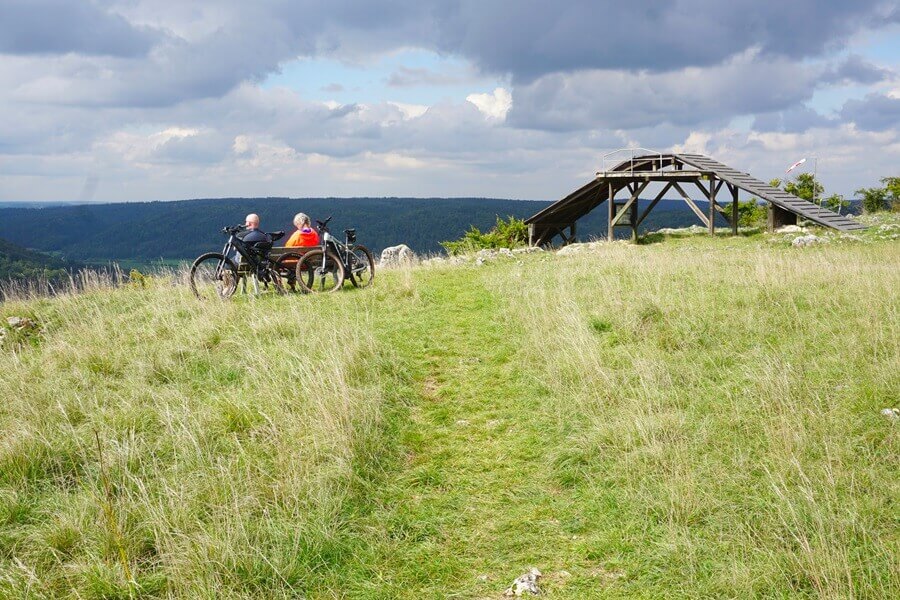 Auch Radfahrer gönnen sich hier eine Pause. Radfahrer sitzen auf einer Bank in der Nähe einer Startrampe